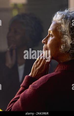 Des femmes africaines américaines séniors attentionnés qui regardent la fenêtre ensoleillée Banque D'Images