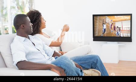 Couple sitting on couch ensemble à la maison à regarder la télévision dans le salon Banque D'Images