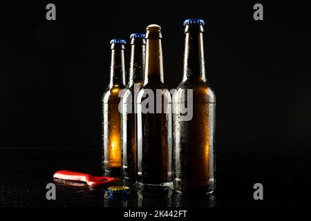 Illustration d'un ouvre-bouteille rouge et de quatre bouteilles de bière, dont une ouverte, avec un espace de copie sur le noir Banque D'Images