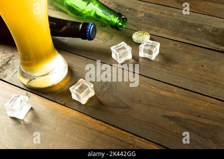 Image de bouteilles de bière, de glaçons et de verre de bière sur table en bois, avec espace de copie Banque D'Images