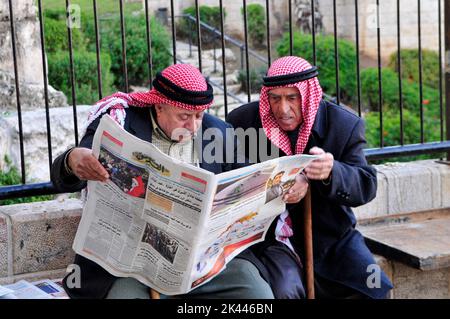 Des hommes palestiniens âgés lisant le journal du matin près de la porte de Damas à Jérusalem-est. Banque D'Images