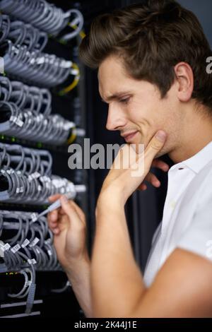 Prêt à vous remettre en ligne. Un technicien informatique qui connecte les câbles. Banque D'Images