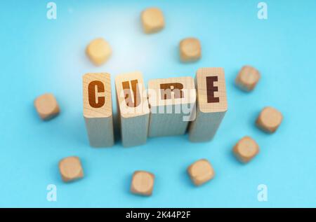 Concept de médecine. Sur fond bleu, cubes en bois et Jenga avec l'inscription - CURE Banque D'Images