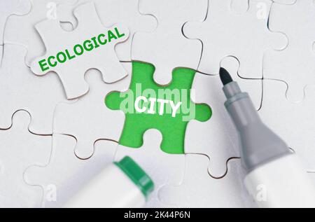 Concept d'écologie. Les puzzles blanches se trouvent sur un fond vert, à la place d'un puzzle ouvert il est écrit - ville écologique Banque D'Images