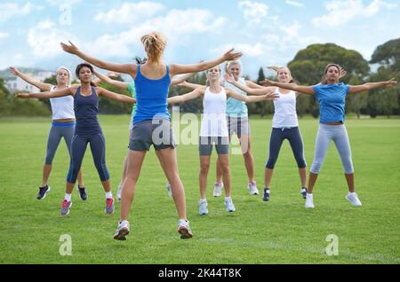 Seulement dix de plus. Un groupe de jeunes femmes qui font des sauts sur un site sportif. Banque D'Images