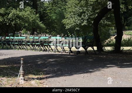 Longue rangée de chaises historiques (vides) dans le parc Cișmigiu à Bucarest, Roumanie Banque D'Images