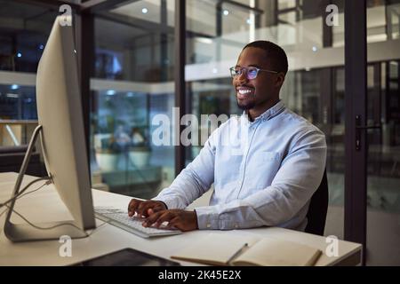 Ordinateur, homme d'affaires africain et travail de nuit dactylographiant sur le clavier pour la recherche d'entreprise au bureau. Professionnel, heureux et homme noir planification a Banque D'Images