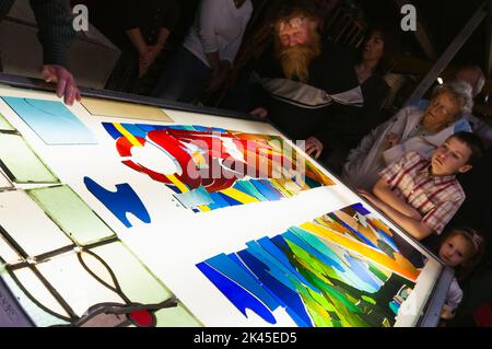 Regard sur les visiteurs comme ils sont donnés une démonstration sur la façon de construire des vitraux Banque D'Images