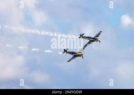 Deux avions Hispano HA-1112 Buchon - un avion militaire 1950s de couleurs allemandes, volant à l'Airshow de Duxford, Musée impérial de la guerre, Duxford Cambridgeshire Royaume-Uni Banque D'Images