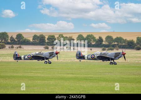WW2 avions - deux spitfires se départir de la piste au Musée impérial de la guerre, Duxford Cambridgeshire Royaume-Uni Banque D'Images