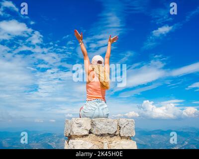 Jeune fille assise sur une pierre avec une belle vue depuis le sommet du Mont Ventoux Banque D'Images