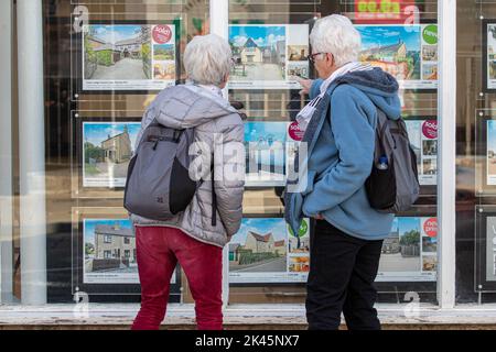 La photo datée de 29 septembre montre les gens regardant dans les fenêtres d'agents immobiliers à Ely, Cambridgeshire, que l'inquiétude au sujet de l'hypothèque continue. Une « bombe à retardement » de prêts hypothécaires attend si les taux d'intérêt britanniques augmentent à la suite des prévisions du marché, a averti Martin Lewis. S’exprimant sur le Good Morning Britain d’ITV, le champion du consommateur a suggéré que ceux qui avaient des prêts hypothécaires à taux variable ou des offres à taux fixe arrivant à échéance dans les trois à cinq prochains mois pourraient consulter un site Web de comparaison pour voir ce qui est actuellement disponible. Banque D'Images