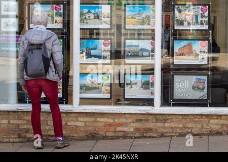 La photo datée de 29 septembre montre les gens regardant dans les fenêtres d'agents immobiliers à Ely, Cambridgeshire, que l'inquiétude au sujet de l'hypothèque continue. Une « bombe à retardement » de prêts hypothécaires attend si les taux d'intérêt britanniques augmentent à la suite des prévisions du marché, a averti Martin Lewis. S’exprimant sur le Good Morning Britain d’ITV, le champion du consommateur a suggéré que ceux qui avaient des prêts hypothécaires à taux variable ou des offres à taux fixe arrivant à échéance dans les trois à cinq prochains mois pourraient consulter un site Web de comparaison pour voir ce qui est actuellement disponible. Banque D'Images