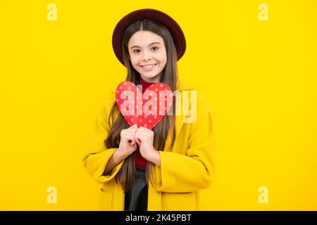 Joyeux portrait d'adolescent. Saint-Valentin. Rêvant enfant adolescent mignon avec coeur rouge. Fille souriante. Banque D'Images