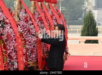 (220930) -- BEIJING, le 30 septembre 2022 (Xinhua) -- Xi Jinping redresse le ruban rouge sur le panier de fleurs lors d'une cérémonie pour présenter les paniers de fleurs aux héros nationaux tombés sur la place Tian'anmen à Beijing, capitale de la Chine, le 30 septembre 2022. Xi Jinping et d'autres dirigeants du Parti communiste de Chine et de l'État ont assisté vendredi matin à une cérémonie sur la place Tian'anmen à Pékin pour présenter des paniers de fleurs aux héros nationaux tombés. L'événement a eu lieu pour marquer la Journée des martyrs, un jour avant la Journée nationale en Chine. Les autres dirigeants étaient Li Keqiang, Li Zhanshu, Wang Yang, Wang Huning, Banque D'Images