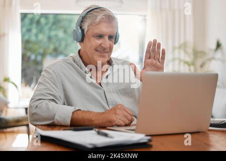 Passez des appels vidéo, un ordinateur portable et un WAVE avec un homme d'affaires senior qui discute en ligne avec un casque et un ordinateur à la maison. Conférence, Internet et communication Banque D'Images