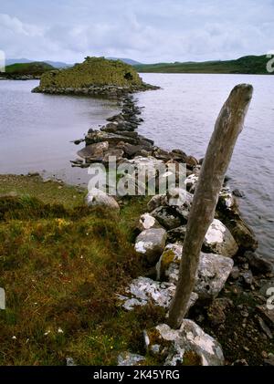 En regardant S le long de la chaussée en pierre menant à Dun Baravat Iron Age, il a gallerié dun sur une petite île du Loch Barabhat, BERNERA, Isle of Lewis, Écosse, Royaume-Uni. Banque D'Images