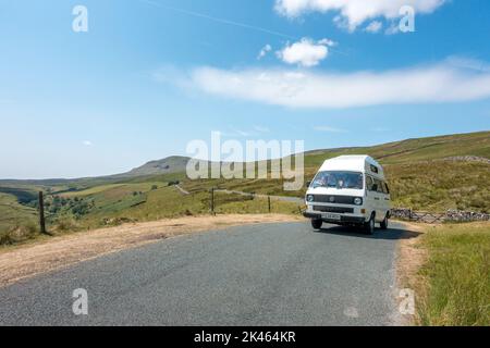 Campervan d'époque VW en tournée dans les Yorkshire Dales avec la montagne de Pen y-ghent en arrière-plan), Royaume-Uni Banque D'Images