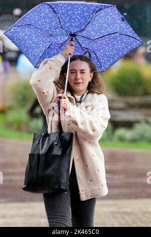 Une femme lutte avec son parapluie pendant le temps humide et venteux à Birmingham. Date de la photo: Vendredi 30 septembre 2022. Banque D'Images