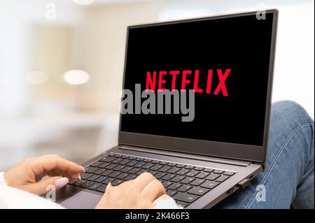 Etats-Unis, NEW YORK 30 septembre 2022 : ordinateur portable avec le logo de Netflix, un fournisseur de services de médias américain. Femme tenant un ordinateur portable avec le logo netflix Banque D'Images