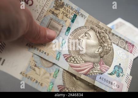 Payer, donner, recevoir de l'argent polonais. Main avec billet de banque de 500 zloty. Salaire Pologne. Banque D'Images