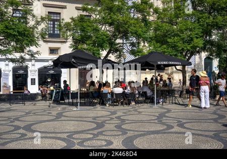 Aveiro, Portugal - 14 août 2022: Personnes assises en groupes sous des parasols dans la rue au café-bar Banque D'Images