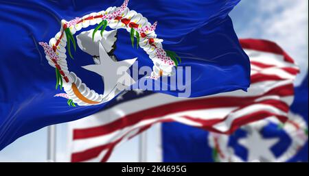 Drapeaux des îles Mariannes du Nord agitant dans le vent avec le drapeau américain par temps clair. Les îles Mariannes du Nord sont un territoire non incorporé et Banque D'Images