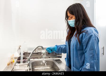 Une jeune scientifique féminine déshydratant des échantillons de tissus inclus en paraffine en laboratoire. Élimination de la paraffine à base de xylène. Banque D'Images