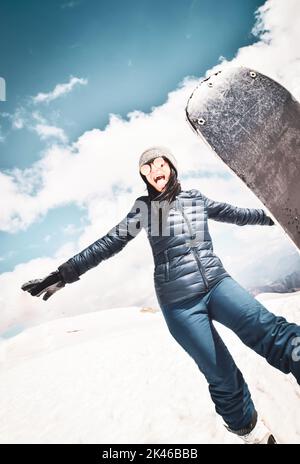 Heureuse excitée fraîche caucasienne brune femme avec le ciel poser dans la tenue d'hiver dans les montagnes.Copier coller l'arrière-plan vertical en haut à gauche Banque D'Images
