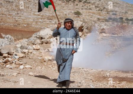 Naplouse, Palestine. 30th septembre 2022. Un manifestant palestinien fuit des canisters à gaz lacrymogène tirés par les forces israéliennes lors de la manifestation contre les colonies israéliennes dans le village de Beit Dajan, près de la ville de Naplouse, en Cisjordanie. (Photo de Nasser Ishtayeh/SOPA Images/Sipa USA) crédit: SIPA USA/Alay Live News Banque D'Images