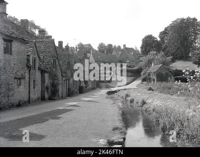 1966, image historique d'un village Cotswold. Une grande zone dans le sud-ouest de l'Angleterre, les Cotswolds sont célèbres pour leur paysage anglais et de jolis villages à l'architecture distincte, la plupart des bâtiments en pierre Cotswold. Banque D'Images