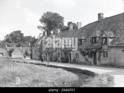 1966, image historique d'un village Cotswold. Une grande zone dans le sud-ouest de l'Angleterre, les Cotswolds sont célèbres pour leur paysage anglais et de jolis villages à l'architecture distincte, la plupart des bâtiments en pierre Cotswold. Banque D'Images