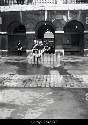 1958, historique, Kings Life Guards, cérémonie traditionnelle dans la cour intérieure à Horse Guards, un bâtiment historique à Whitehall, Westminster, Londres, Angleterre, Royaume-Uni. Banque D'Images