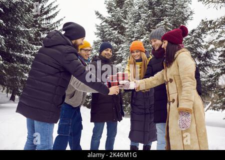 Groupe de jeunes amis heureux s'amuser en plein air et boire du café dans le parc d'hiver Banque D'Images