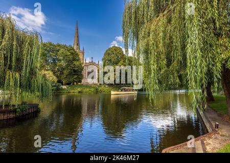 Un bateau de croisière sur la rivière et une église de la Sainte Trinité de l'autre côté de la rivière à Stratford-upon-Avon, Warwickshire, Angleterre Banque D'Images