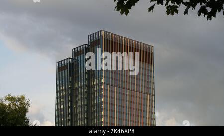 Bâtiment moderne de ville en verre, isolé dans un ciel nuageux Banque D'Images