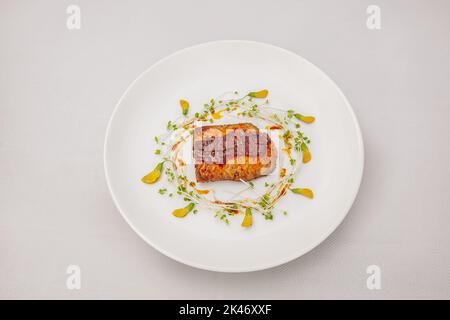 Saumon poêlé avec sauce aux fruits de la passion et fleur de sesban, isolé sur fond blanc, vue du dessus Banque D'Images