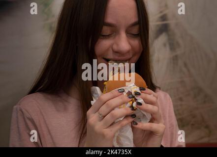 Kiev, Ukraine. 30th septembre 2022. Nastya Yurevitch, 17 ans, a vu apprécier sa première bouchée de hamburger au restaurant McDonald’s depuis le début de la guerre. « J'ai été très heureux quand j'ai appris de Telegram qu'ils rouvrent. J'avais 3 fois McDonald's en un mois. Mais à cause de la guerre, nous ne l’avons pas mangé pendant longtemps. Nous avons oublié ce sentiment ». Chaîne de restauration rapide McDonald’s a rouvert 10 restaurants à Kiev, reprenant leur service de restauration sur place, la première fois après la fermeture de tous ses restaurants en mars. La chaîne de restauration rapide a fait une annonce surprise sur son compte facebook, mais un avertissement pourrait être présent Banque D'Images