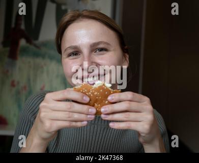 Kiev, Ukraine. 30th septembre 2022. Maryna Tarandiuk, 25 vu tenant le hamburger McChicken. « J'aime McChicken. Je l'ordonne toujours même avant la guerre. En avoir un peu, ça me rappelle l’esprit avant la guerre ». Maryna a déclaré qu'elle avait essayé d'autres McDonald's lorsqu'elle s'est rendue dans d'autres pays, mais rien ne compare la chaîne de restaurants de retour à la maison. « Nous sommes très heureux de la réouverture parce que je crois que cela a un impact positif sur l'économie. » Chaîne de restauration rapide McDonald’s a rouvert 10 restaurants à Kiev, reprenant leur service de restauration sur place, la première fois après la fermeture de tous ses restaurants en mars. Crédit: SIPA US Banque D'Images