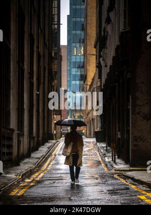 Glasgow, Royaume-Uni. 30th septembre 2022. Royaume-Uni Un jour pluvieux très humide à travers une grande partie du Royaume-Uni aujourd'hui que le temps humide a traversé. Pic montre un homme qui marche dans une ruelle étroite dans le centre de Glasgow aujourd'hui à l'abri du temps humide sous son parapluie. Pic Credit: phil wilkinson/Alay Live News Banque D'Images