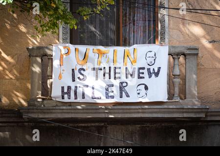 Tbilissi, Géorgie - 18 septembre 2022: Un écriteau sur le balcon d'une maison résidentielle, disant que Poutine est le nouveau Hitler. Banque D'Images