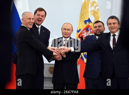 (G-D) les chefs de la région de Kherson nommés par Moscou, Vladimir Saldo Zaporizhzhia, Yevgeny Balitsky, le président russe Vladimir Poutine, le chef séparatiste Donetsk Denis Pouchilin et le chef séparatiste Lugansk Leonid Pasechnik se joignent à la main après avoir signé les traités lors d'une cérémonie d'adhésion de quatre régions ukrainiennes à la Russie, à Moscou. La Russie vendredi 30 septembre 2022. Les dirigeants séparatistes des régions annexées de Donetsk, Lugansk, Kherson et Zaporizhzhya sont arrivés à Moscou pour signer des traités visant à amorcer le processus d'absorption de certaines parties de l'Ukraine en Russie. Photo par Kremlin Pool/UP Banque D'Images