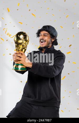 Les jeunes hommes ont remporté le trophée réplique de la coupe du monde de la FIFA. Concept sportif et de célébration Banque D'Images