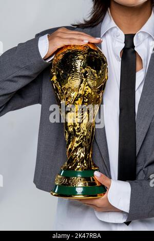 Fille tenant le trophée réplique de la coupe du monde de football de la FIFA Banque D'Images