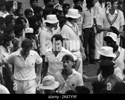 Les équipes s'en vont à la fin du match, onze du président du conseil de cricket du Sri Lanka contre l'Angleterre, Colombo, Sri Lanka novembre 1984. De gauche à droite, Pat Pocock, Tim Robinson et Graham Fowler. Bowlers Norman Cowans (au milieu à droite (en bonnet beanie) et en haut à droite, Neil Foster. Banque D'Images