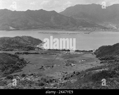 Vue en noir et blanc - vers le nord - de Starling Inlet, avec l'école Kuk po, (centre gauche), et Kuk po Marsh, - Sha Tau Kok de l'autre côté de l'eau, (centre droit). Hung Fa Leng (Robins Nest) en haut à gauche. Nouveaux Territoires du Nord-est, Hong Kong 1984 Banque D'Images