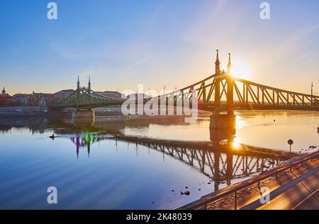 Profitez du lever de soleil doré, qui se reflète sur la surface calme du Danube et la silhouette du pont Art Nouveau Liberty, Budapest, Hongrie Banque D'Images