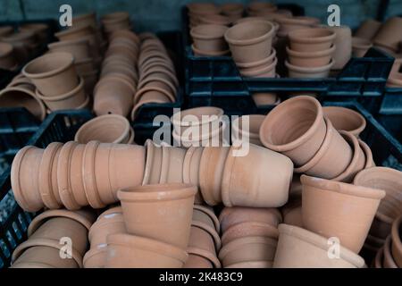 Gros plan des piles de pots de fleurs de terre cuite anciens et altérés dans le hangar de jardinage Banque D'Images