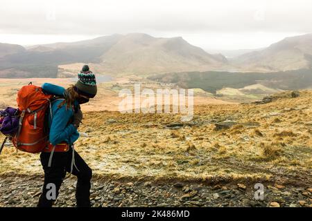 Les randonneurs féminins grimpent en montagne par temps froid et brumeux le matin. Sentier de randonnée jusqu'à Snowdon. Alpinistes grimpant montagne dans la belle nature terre Banque D'Images