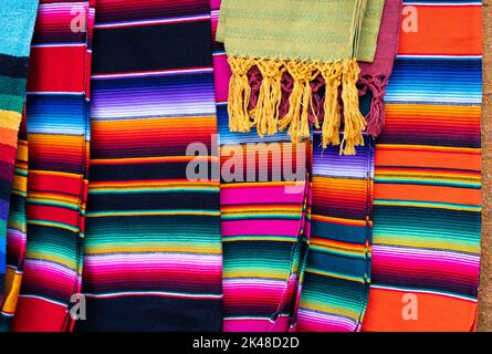 Couvertures de bandes de serape mexicaine colorées sur le marché de rue. Vente de souvenirs artisanaux traditionnels du Mexique Banque D'Images